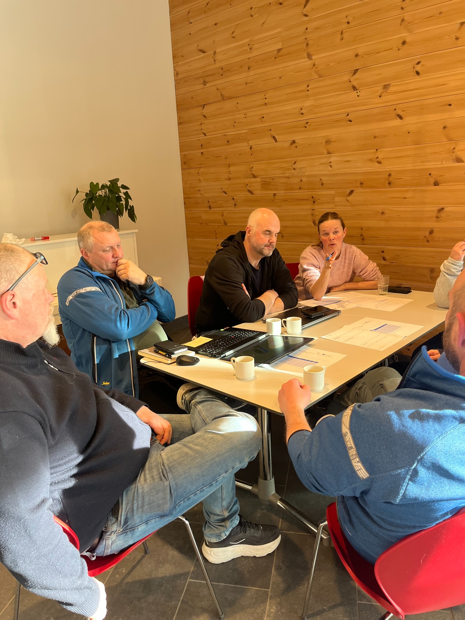 Deltakere arbeider med oppgaver rundt et bord